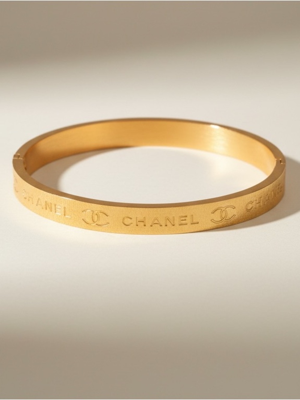 Gold-tone logo hinged oval bracelet, Elegant Chic